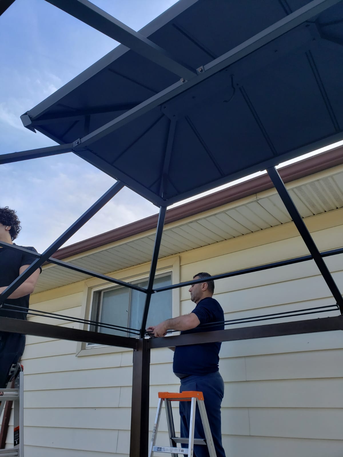 Mid-install gazebo with team on ladders